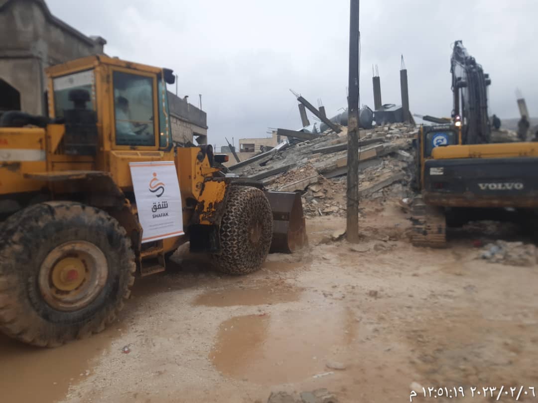 Bucket loader and Steam shovel working on pile of debris