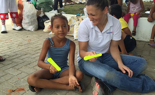Kate sitting with a child and a toy
